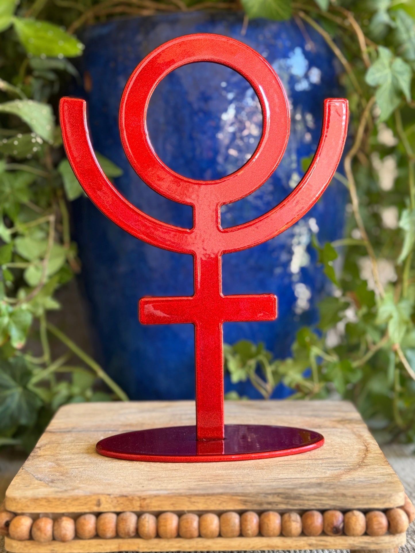 Pluto, red metal statue